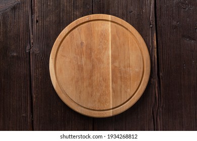 Empty Round Pizza Or BBQ Board On Dark Wooden Table