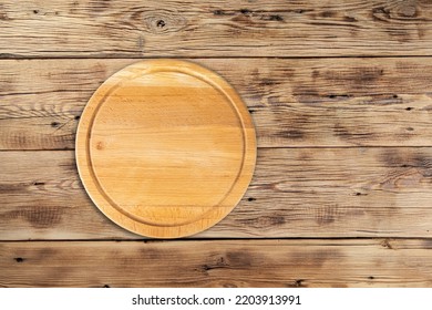 Empty Round Pizza Board On Wooden Table