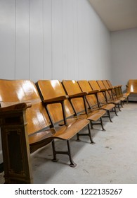 Empty Row Of Old Wooden Chairs Against A Wall
