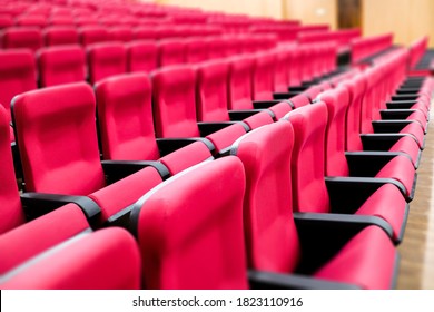 Empty Rows Of Seats Of An Auditorium With Red Reclining Rows Of Seats And False Ceiling Led Lights