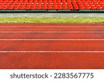 Empty running track and red plastic chairs on a sports stadium
