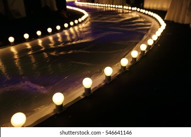 Empty Runway Fashion Show with Ball glowing lighting along walk way with plastic white floor in the dark