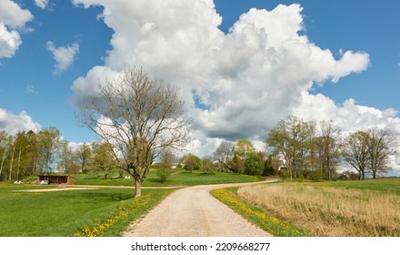 An Empty Rural Road Through The Field And Forest. Glowing Sky After The Rain. Tourism, Road Trip, Freedom, Vacations, Logistics, Remote Places Concepts