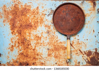 Empty Rusted Cast Iron Pan On Rust Background. Top View. Copy Space