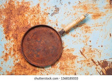 Empty Rusted Cast Iron Pan On Rust Background. Top View. Copy Space