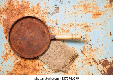 Empty Rusted Cast Iron Pan On Rust Background. Top View. Copy Space