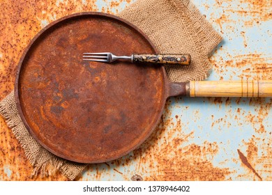 Empty Rusted Cast Iron Pan On Rust Background. Top View. Copy Space