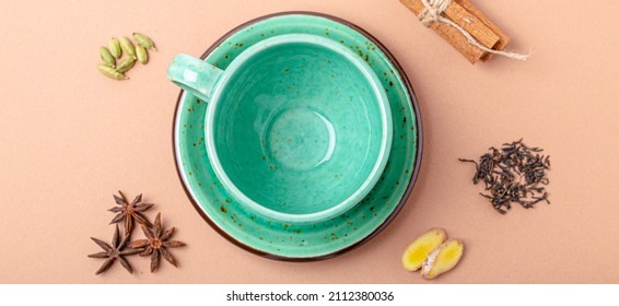 Empty Rustic Porcelain Green Teacup With Saucer And Spices Ingredients For Making Healthy Indian Tea Drink Masala Chai From Above On Simple Beige Minimal Background 