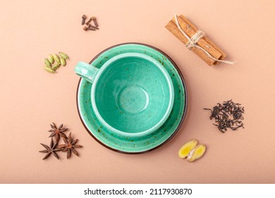 Empty Rustic Porcelain Green Teacup With Saucer And Spices Ingredients For Making Healthy Indian Tea Drink Masala Chai From Above On Simple Beige Minimal Background 