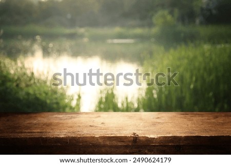 Empty rustic table in front of countryside background. product display and picnic concept