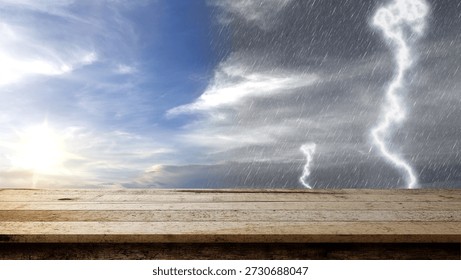Empty rustic wooden table with a background of contrasting weather, showing a bright sunny sky on one side and a dark stormy sky with rain and lightning on the other