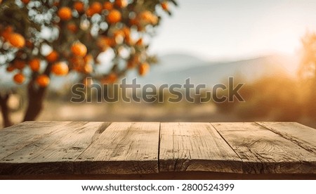 An empty rustic wooden table provides a perfect foreground for a blurred backdrop of an orange grove bathed in the warm glow of a sunset, ideal for product display or agricultural themes.