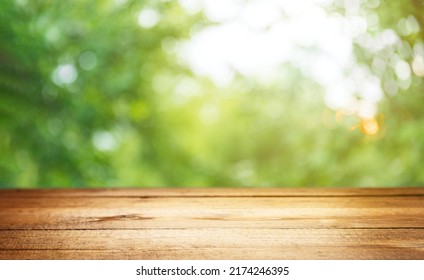 Empty rustic wooden texture of old wood table top, blur against green park with defocused sunlight, blurred foliage backyard background. Display mock up, montage your product, design key visual layout - Shutterstock ID 2174246395