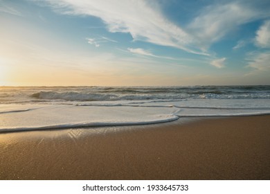 Empty sand beach at sunset and cloudy sky. Relaxation, calm, tranquility, vacation concept, copy space