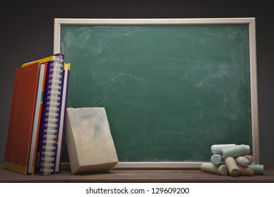 Empty school blackboard with books and sponge