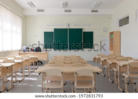 empty school class before final exams. desks and chairs are neatly arranged in three rows. overall plan