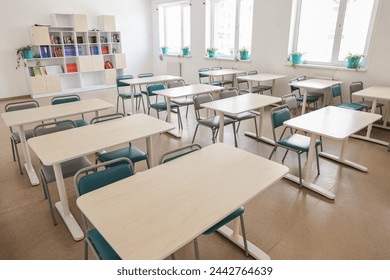 Empty school classroom with desks, windows and chairs - Powered by Shutterstock