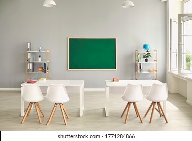 Empty school classroom interior with desks and chairs, space for text on chalkboard. Modern schoolroom with furniture - Shutterstock ID 1771284866