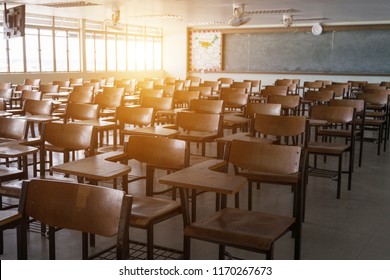 Empty school classroom with many wooden chairs. Wooden chairs in classroom. Wooden arranged in classroom. Empty classroom with vintage tone wooden chairs. Back to school concept.