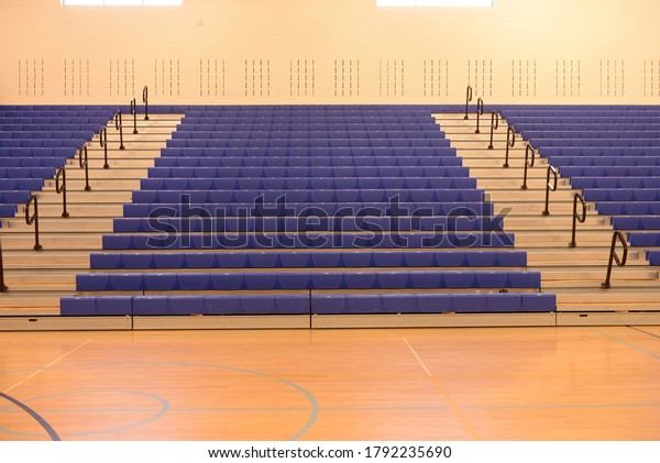 Empty school gym bleachers\
stands