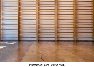 Empty School Gym With Parquet Floor And Wooden Ladder Fixed On Concrete Wall Front View Indoor