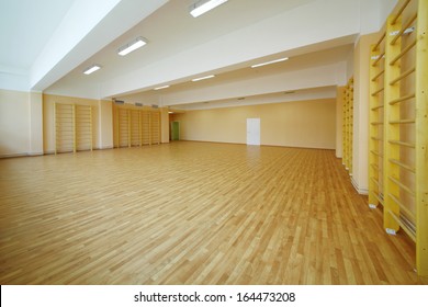 Empty School Gymnasium With Yellow Floor And Climbing Near Walls.