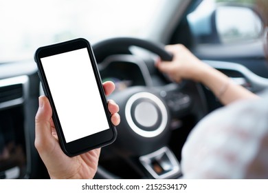 Empty screen smartphone isolated with clipping path. Unrecognizable careless woman using a smartphone while driving a car on highway. Dangerous driving behavior and careless people concept.