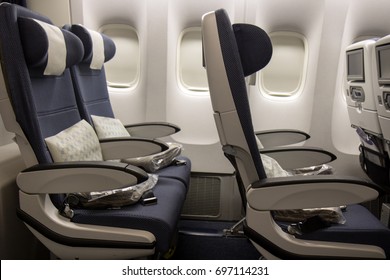 Empty Seat Rows On The Plane. Airplane Without A Passenger. The Board Of A Flying Aircraft With Empty Chairs And Covered Windows.