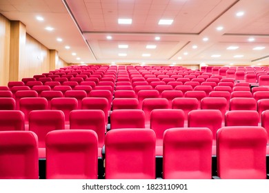 Empty Seats Of An Auditorium With Red Reclining Rows Of Seats And False Ceiling Led Lights