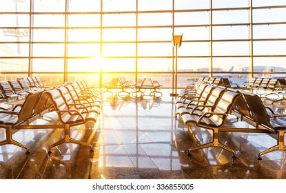 Empty seats in the departure lounge at the airport in the sunset - Powered by Shutterstock