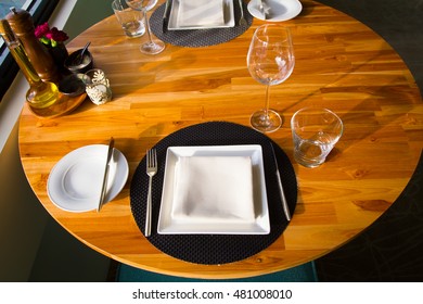 Empty served restaurant table with white tablecloth