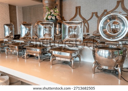 Empty serving new stainless on catering buffet table or buffet restaurant. Culinary business and service for background.