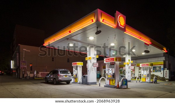 Empty Shell Gas station with a green\
logo at night, price 3.55$ per gallon for regular gas, New York,\
Bronx, 10462, United States of America,\
11.03.2021