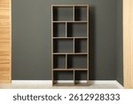 Empty shelving unit and folding screen near grey wall indoors