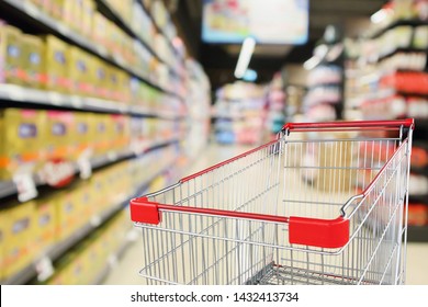 Empty Shopping Cart With Abstract Blur Supermarket Discount Store Aisle And Baby Milk Product Shelves Interior Defocused Background