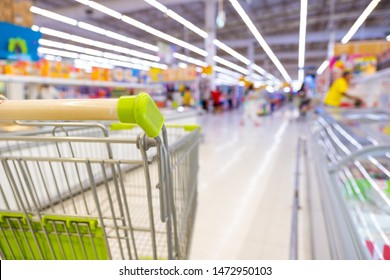 Empty shopping cart in super market or  convenience store concept and shelves in frozen food corner on blurry for background