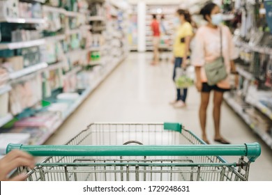 Empty Shopping Cart In The Supermarket Aisle With People