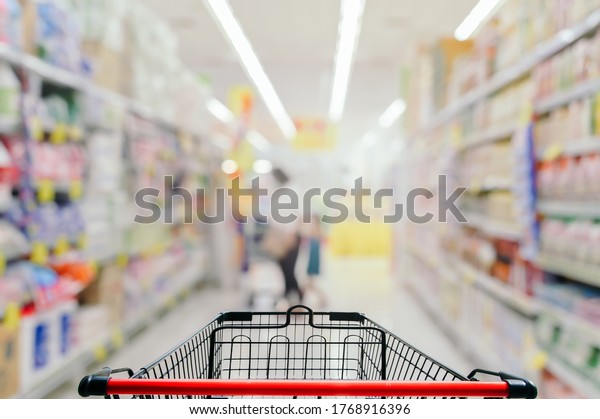 Empty\
shopping cart in supermarket blurred\
background