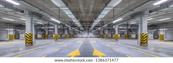 Empty shopping mall\
underground parking lot or garage interior with concrete stripe\
painted columns