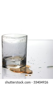 Empty Shot Glass With Spilled Drink On The Table.