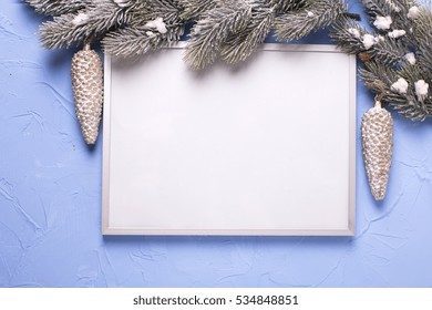 Empty silver frame and Christmas decorations on blue textured  background. Place for text. Mock-up for design.