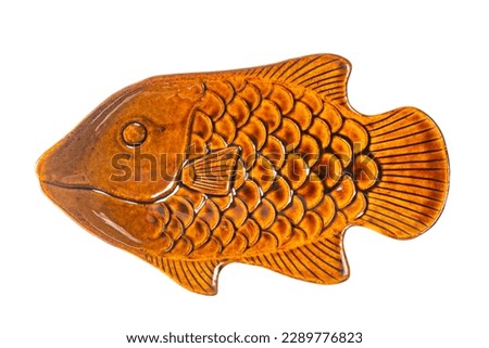 Empty single brown fish shape ceramic plate isolated on white background with clipping path, top view, closeup, horizontal format.