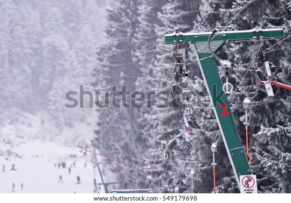 Empty ski\
lift cable in a ski resort during\
snowfall
