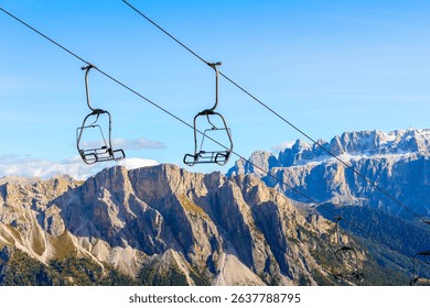 Empty ski lift chairs in off-season repose over Dolomites, Val Gardena mountains, Italy - Powered by Shutterstock - Get 15% off with code: PIKWIZARD15