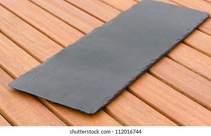 Empty Slate - Black Serving Platter On A Wooden Table Outdoors.