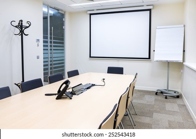 Empty Small Bright Meeting Room With TV Proektor Screen And Flipchart. Modern Design