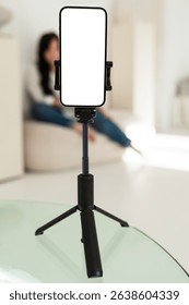 Empty smartphone tripod setup for video recording. Useful for content creation, online meetings, or remote communication in home environment.