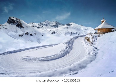 Empty Snow Covered Mountain Road In Winter Landscape