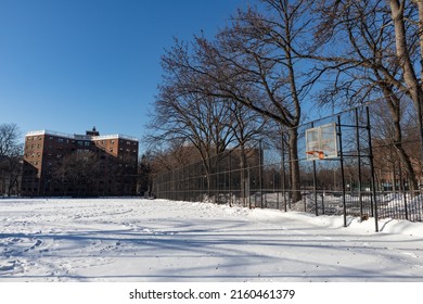 Empty Snow Covered Park With A Basketball Hoop Next To Public Housing In Astoria Queens New York During The Winter