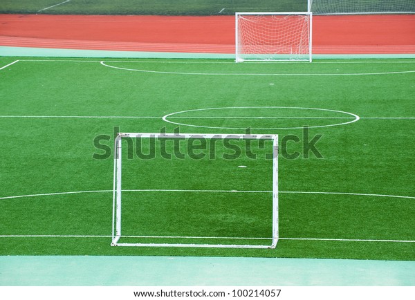 Empty\
soccer field with goal posts and light\
poles.